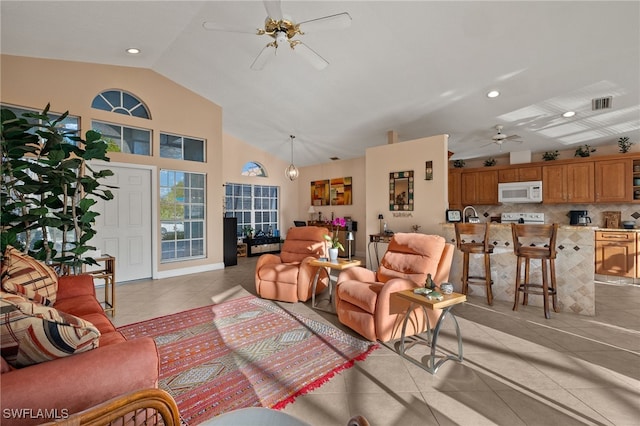 living room with ceiling fan, light tile patterned flooring, and lofted ceiling