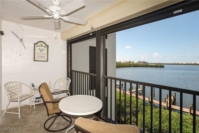 balcony with a water view and ceiling fan