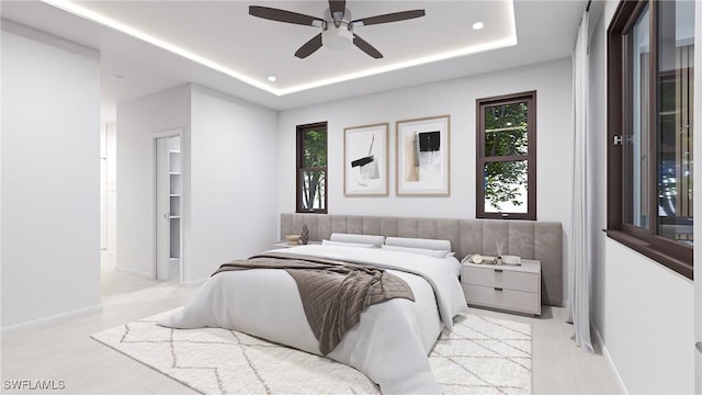 bedroom with ceiling fan and a raised ceiling