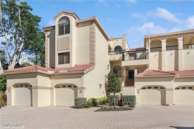 mediterranean / spanish-style house featuring decorative driveway, a balcony, and stucco siding