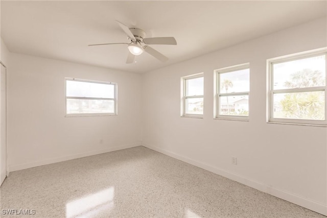 unfurnished room featuring a wealth of natural light and ceiling fan