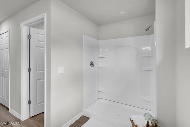 bathroom with hardwood / wood-style flooring and walk in shower