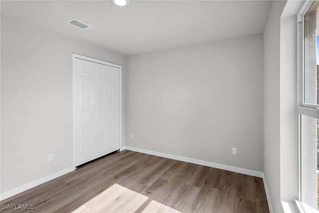 unfurnished bedroom with light wood-type flooring and a closet