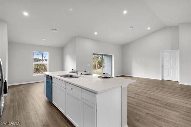 kitchen with white cabinetry, sink, stainless steel dishwasher, an island with sink, and lofted ceiling