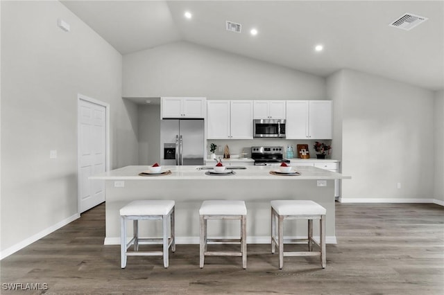 kitchen with a breakfast bar area, a center island with sink, and appliances with stainless steel finishes