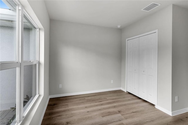 unfurnished bedroom featuring light hardwood / wood-style floors and a closet