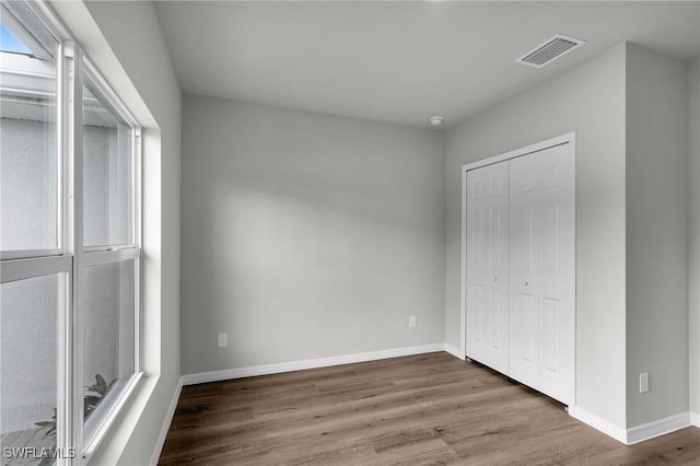 unfurnished bedroom featuring hardwood / wood-style flooring and a closet