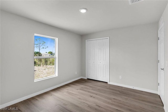 unfurnished bedroom featuring a closet and wood-type flooring