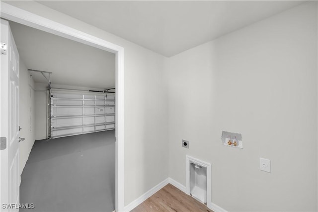 laundry room featuring a garage, laundry area, baseboards, washer hookup, and electric dryer hookup