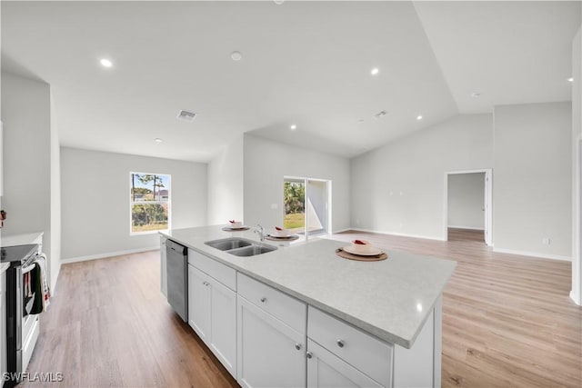 kitchen featuring visible vents, stainless steel appliances, light wood-type flooring, white cabinetry, and a sink