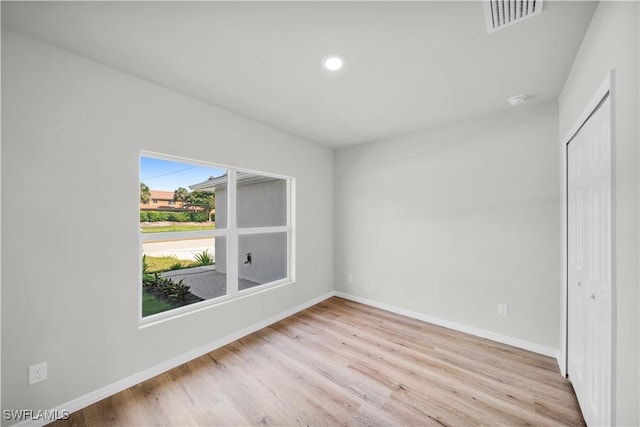 unfurnished bedroom with light wood-style flooring, a closet, visible vents, and baseboards