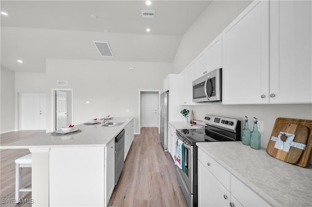 kitchen featuring light wood finished floors, visible vents, white cabinets, appliances with stainless steel finishes, and a sink