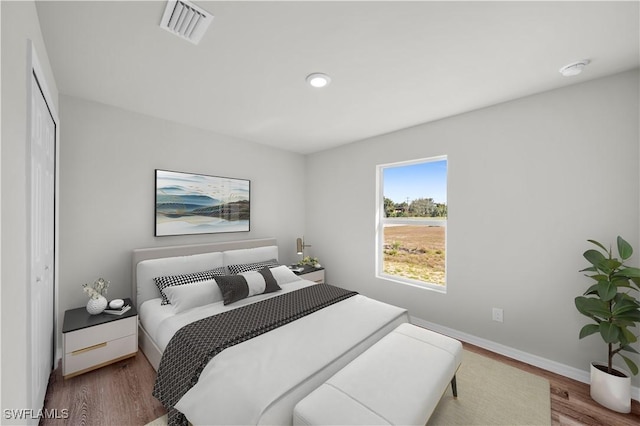 bedroom featuring recessed lighting, visible vents, baseboards, and wood finished floors