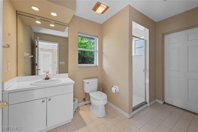 bathroom featuring tile patterned flooring, vanity, toilet, and a shower with shower door