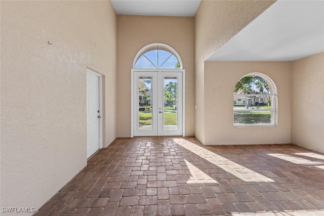 doorway to outside with french doors and a high ceiling