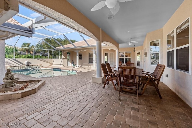 view of patio / terrace featuring glass enclosure, ceiling fan, and a pool with hot tub