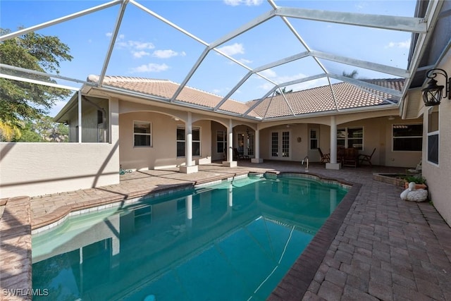 view of pool featuring ceiling fan, a patio, glass enclosure, and french doors