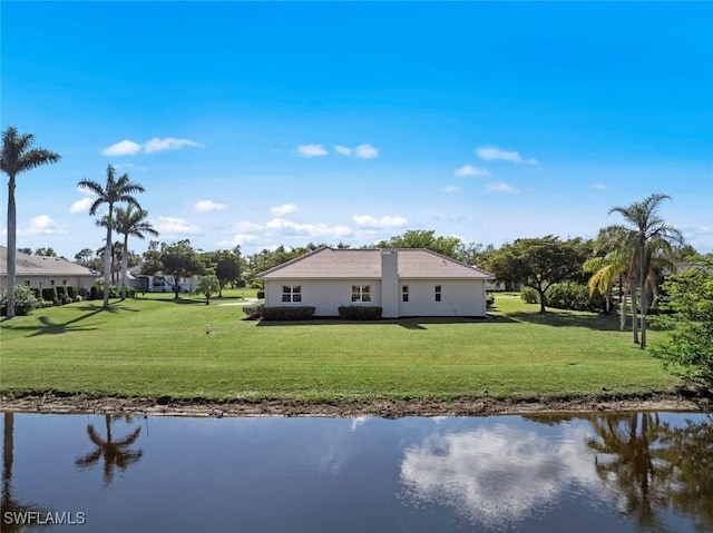 rear view of house with a yard and a water view