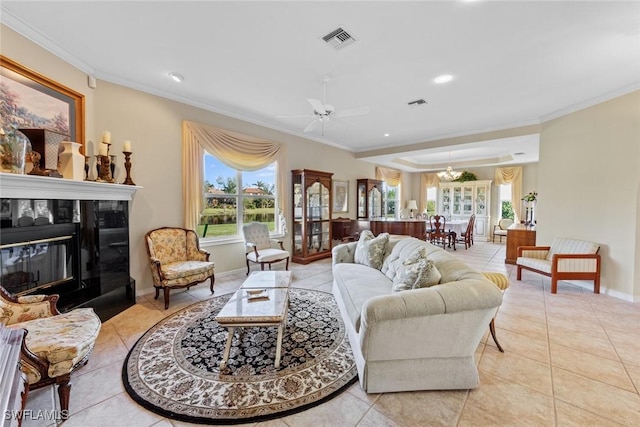 living room with a tile fireplace, plenty of natural light, ornamental molding, and light tile patterned flooring