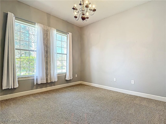 empty room with a notable chandelier and carpet floors