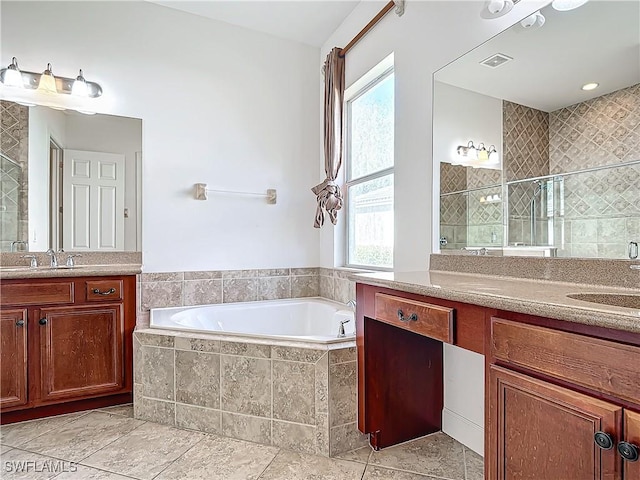 bathroom featuring shower with separate bathtub, vanity, and a wealth of natural light