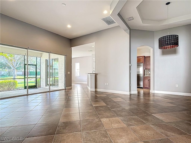 unfurnished room featuring a raised ceiling