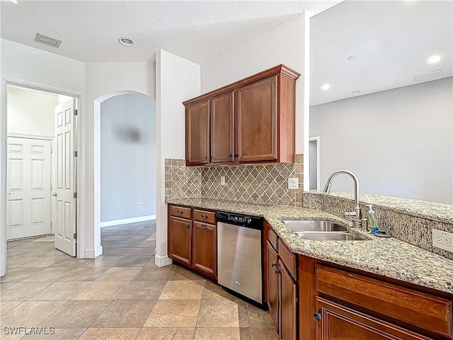 kitchen featuring light stone countertops, backsplash, stainless steel dishwasher, and sink