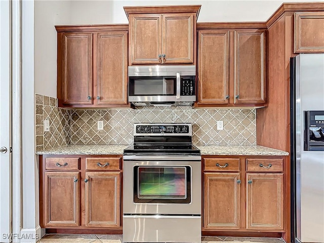 kitchen with decorative backsplash, light stone counters, and appliances with stainless steel finishes