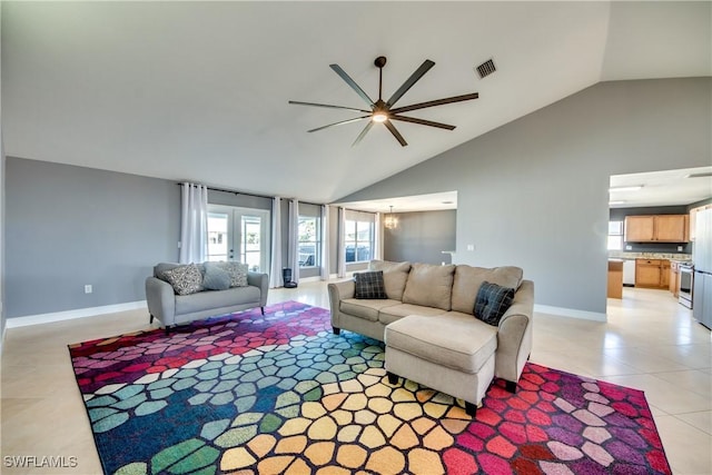 living room with light tile patterned floors, ceiling fan with notable chandelier, and high vaulted ceiling