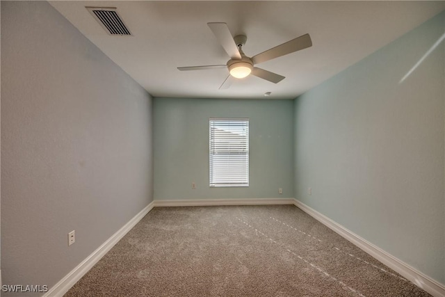 spare room with ceiling fan and carpet