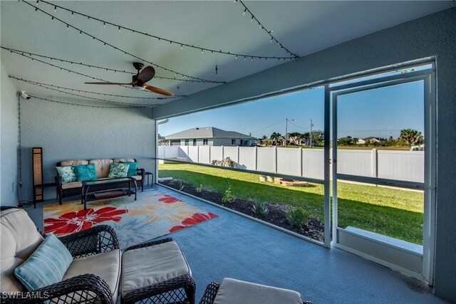 sunroom featuring ceiling fan and plenty of natural light