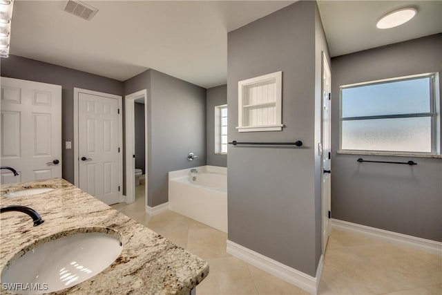 bathroom featuring a bathing tub, tile patterned flooring, toilet, and vanity