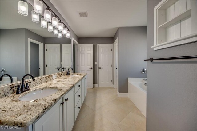 bathroom featuring a bathtub, vanity, and tile patterned flooring