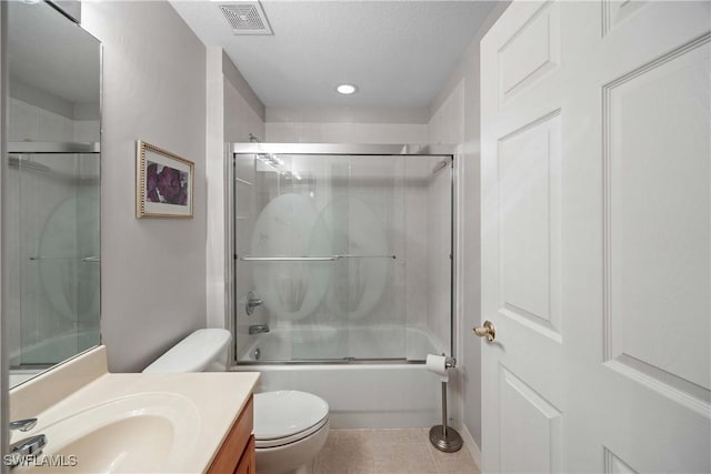 full bathroom with a textured ceiling, vanity, enclosed tub / shower combo, tile patterned flooring, and toilet