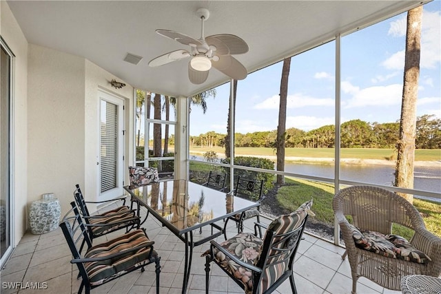 sunroom with a water view and ceiling fan