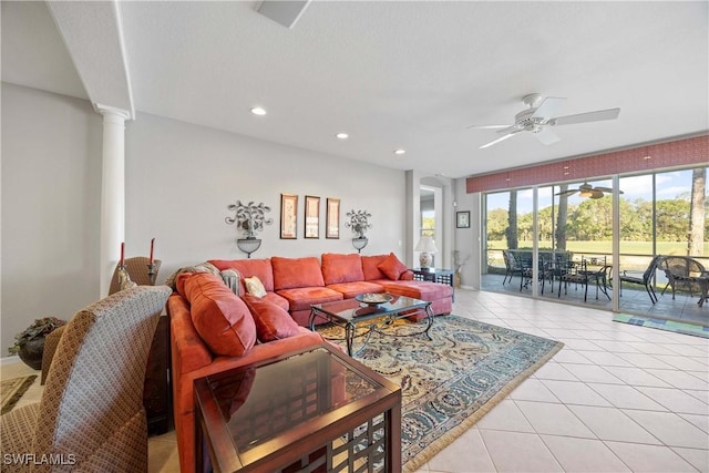 tiled living room with ceiling fan and decorative columns