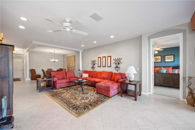 living room with light tile patterned flooring and ceiling fan with notable chandelier