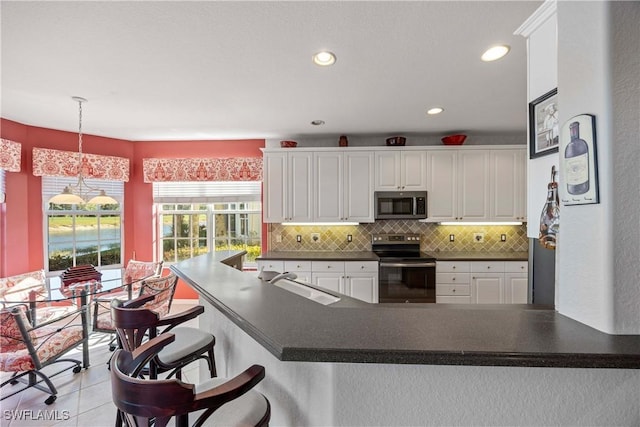 kitchen with decorative backsplash, appliances with stainless steel finishes, sink, decorative light fixtures, and white cabinets