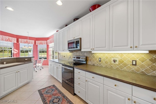 kitchen featuring white cabinets, pendant lighting, and appliances with stainless steel finishes