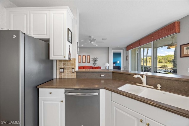 kitchen with white cabinets, sink, ceiling fan, appliances with stainless steel finishes, and tasteful backsplash