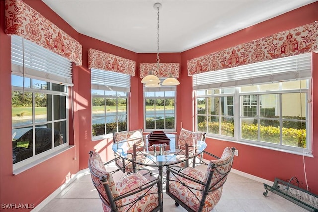 sunroom featuring plenty of natural light and a water view