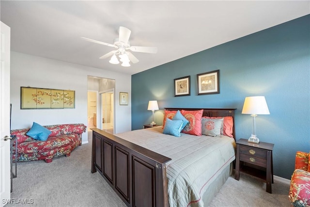 carpeted bedroom with ensuite bathroom and ceiling fan