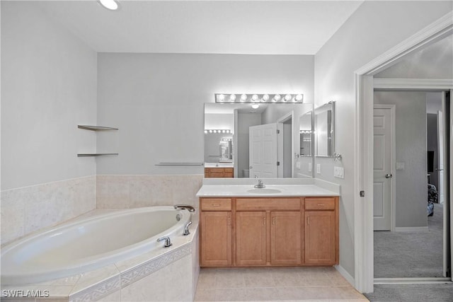 bathroom with tile patterned floors, tiled tub, and vanity