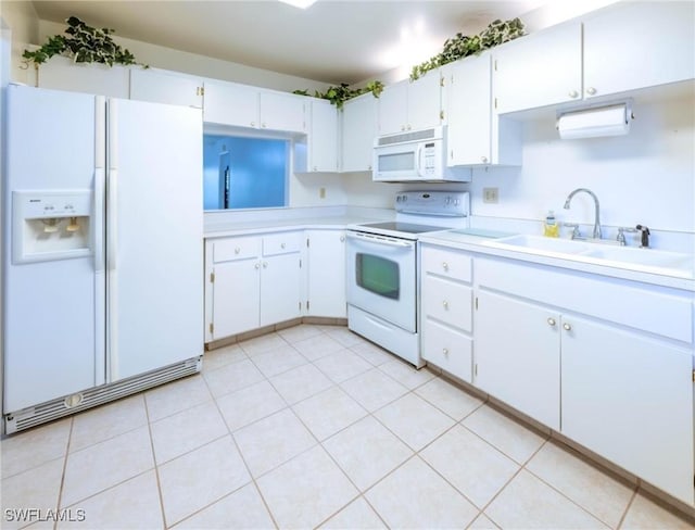 kitchen with white cabinets, light tile patterned floors, white appliances, and sink