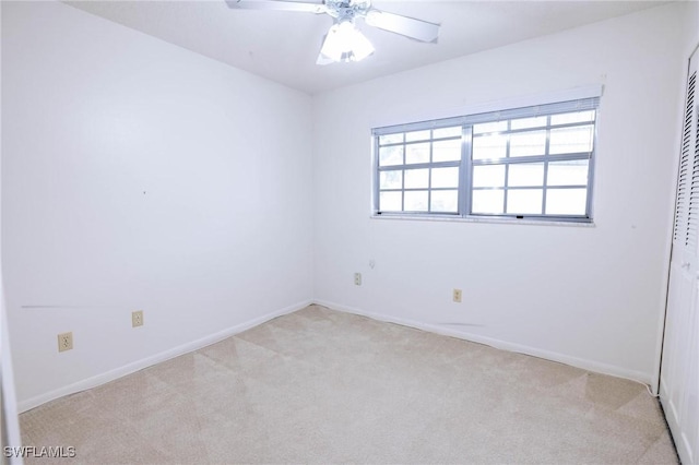 spare room with ceiling fan and light carpet