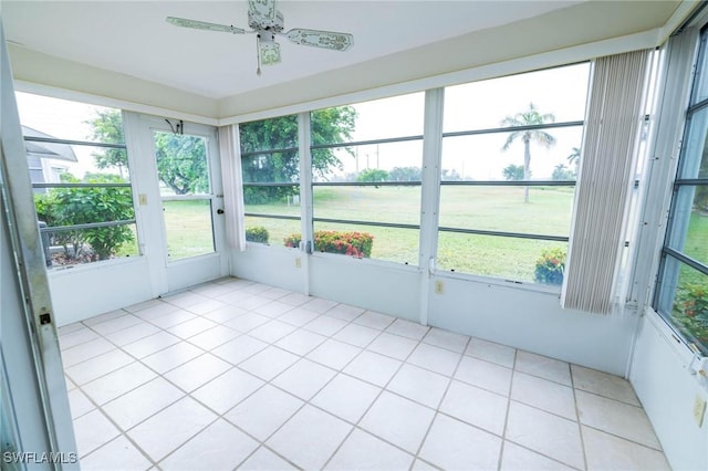 unfurnished sunroom with ceiling fan