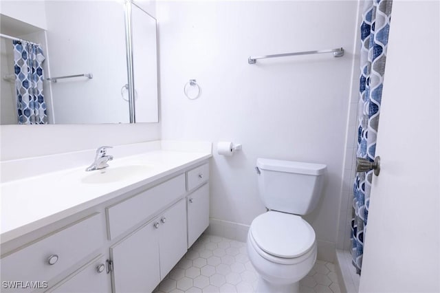 bathroom featuring tile patterned flooring, vanity, toilet, and walk in shower