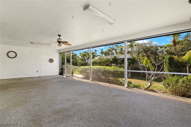 unfurnished sunroom featuring ceiling fan