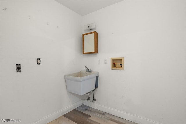 washroom featuring washer hookup, light hardwood / wood-style floors, and sink