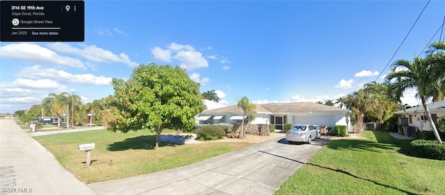 view of front of house featuring a front yard, a garage, and central AC unit